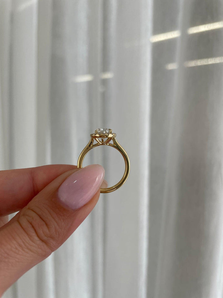 a person holding a ring with a diamond on it