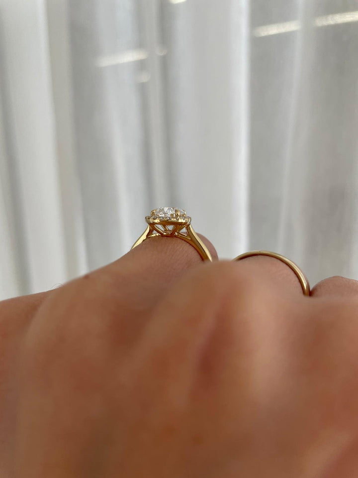 a close up of a person's hand holding a diamond ring