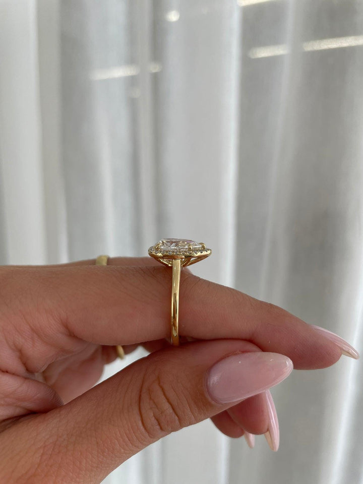 a woman's hand holding a diamond ring