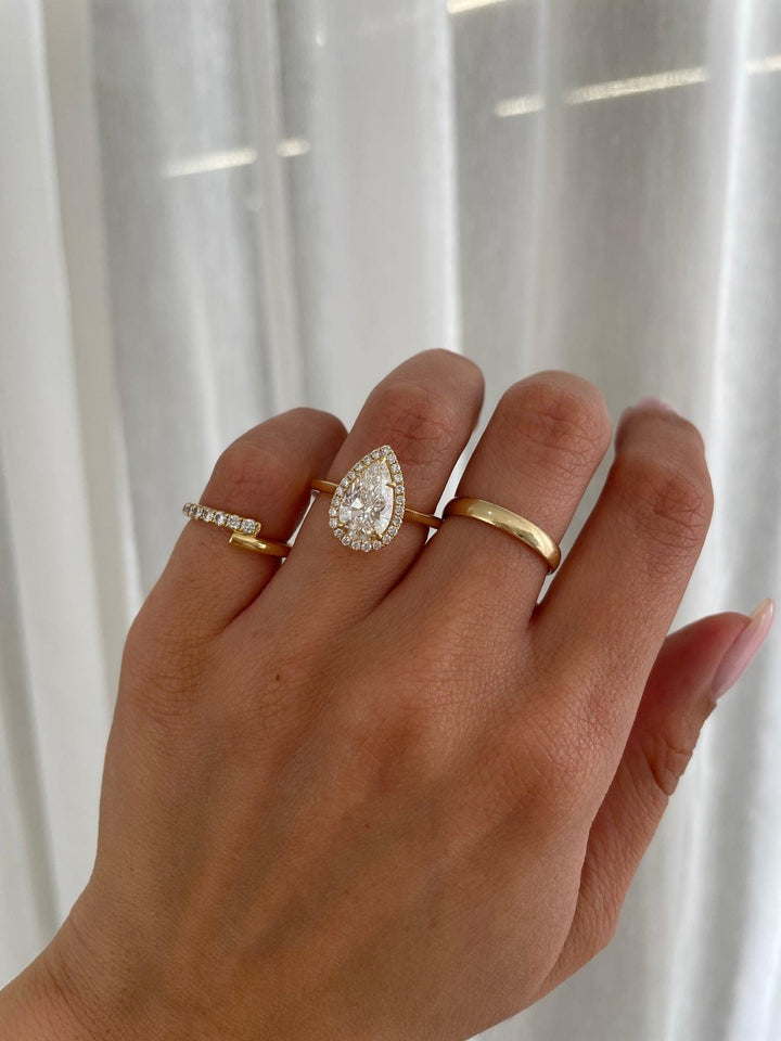 a woman's hand with a gold ring and a diamond ring