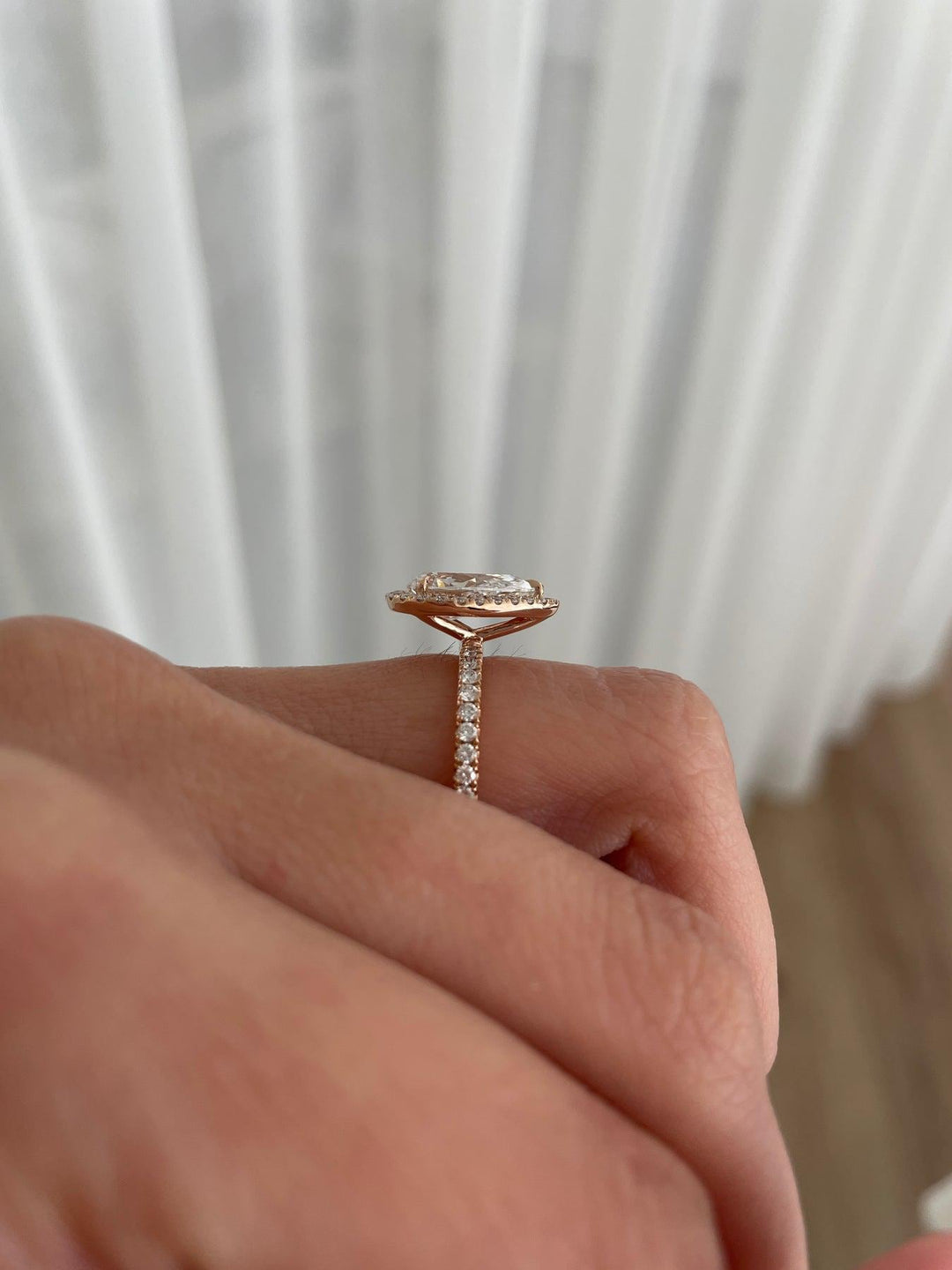 a close up of a person's hand holding a diamond ring