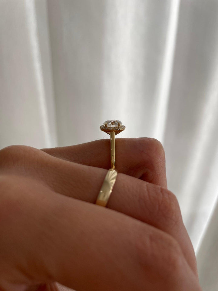 a woman's hand holding a diamond ring